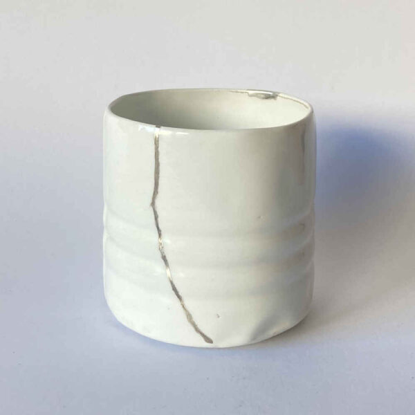 Réparation de céramique à l'aide de la technique de réparation Gintsugi à l'argent sur une tasse.