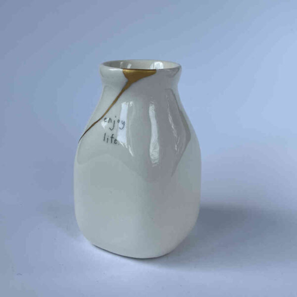 Riparazione di ceramica con la tecnica di riparazione Kintsugi con oro su vaso di ceramica.
